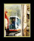 A bulldozer moving a huge rock seen through an abandoned structure thumbnail