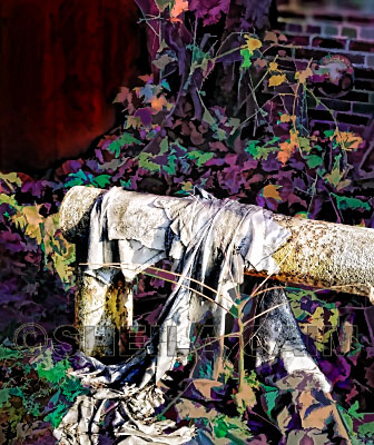 Old rags hanging on a pipe on the ground in front of an abandoned factory