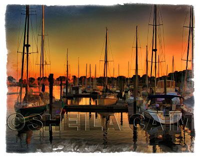 Boats docked at a harbor at sunset