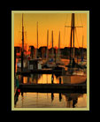 Boats docked at a harbor at sunset thumbnail