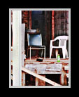 Three empry chairs outside an old factory thumbnail